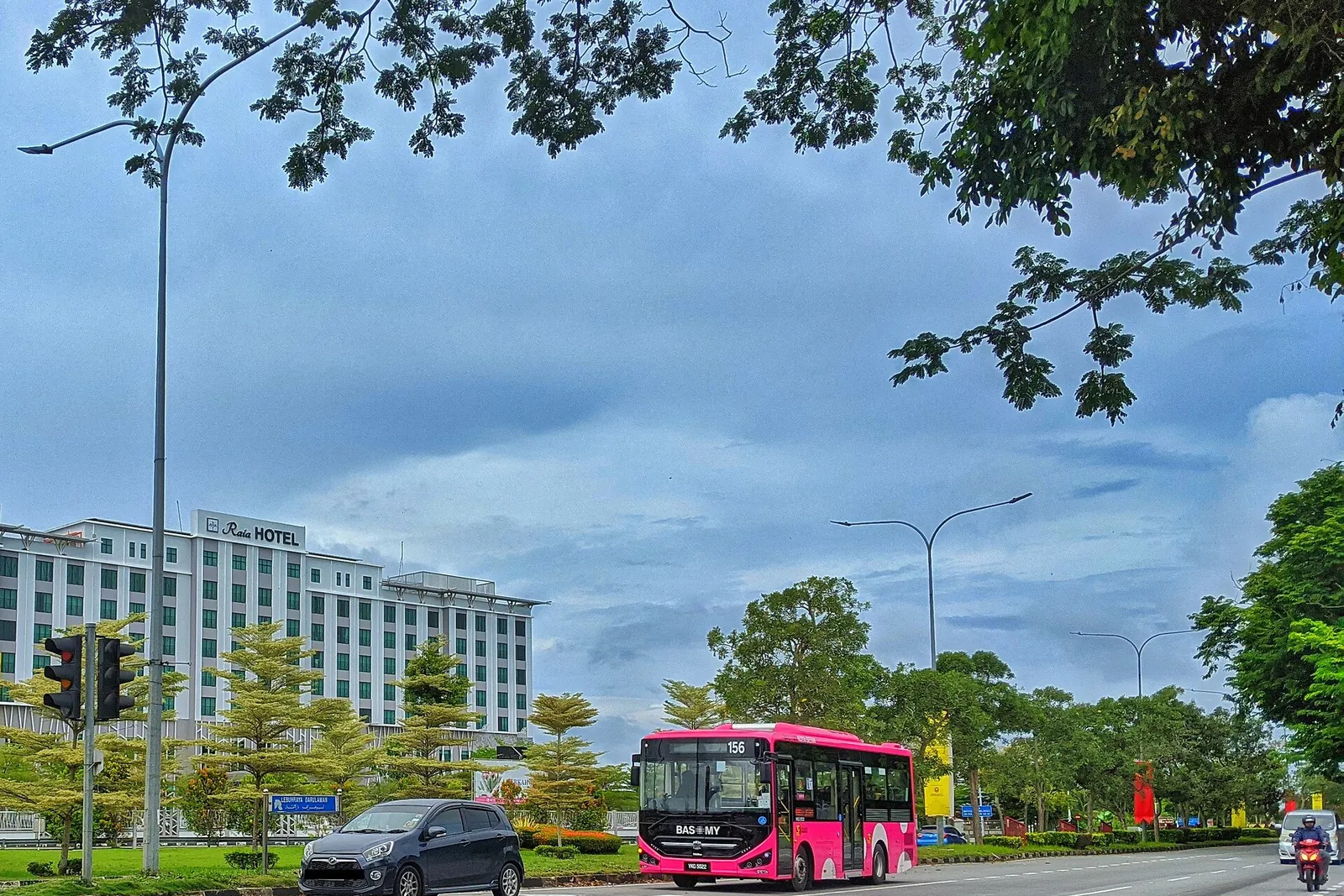 A pink BAS.MY bus on the road in Alor Setar